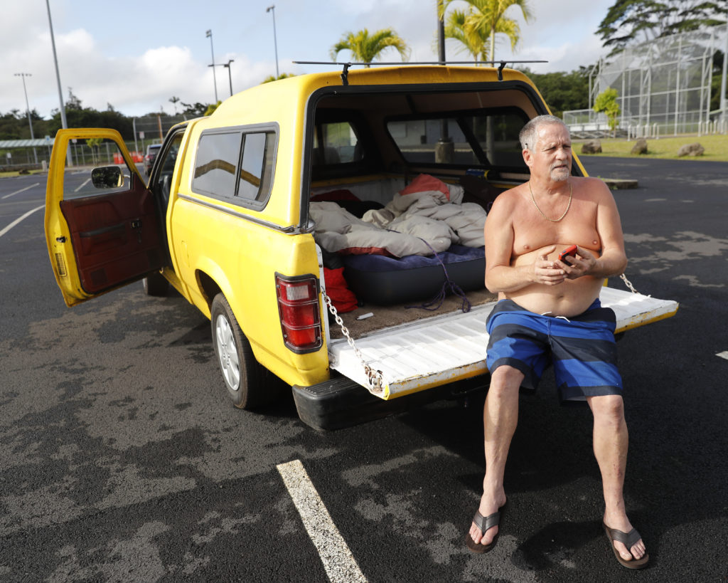 After being forced out of his home at the Leilani Estates due to a mandatory evacuation, Tim Sullivan, 61, sits in his pickup truck near a local shelter, Friday, May 4, 2018, in Pahoa, HI. The eruption took place about a block from Sullivan's home. He and his wife spent the night at a nearby shelter and does not know when they will be able to return. (AP Photo/Marco Garcia)